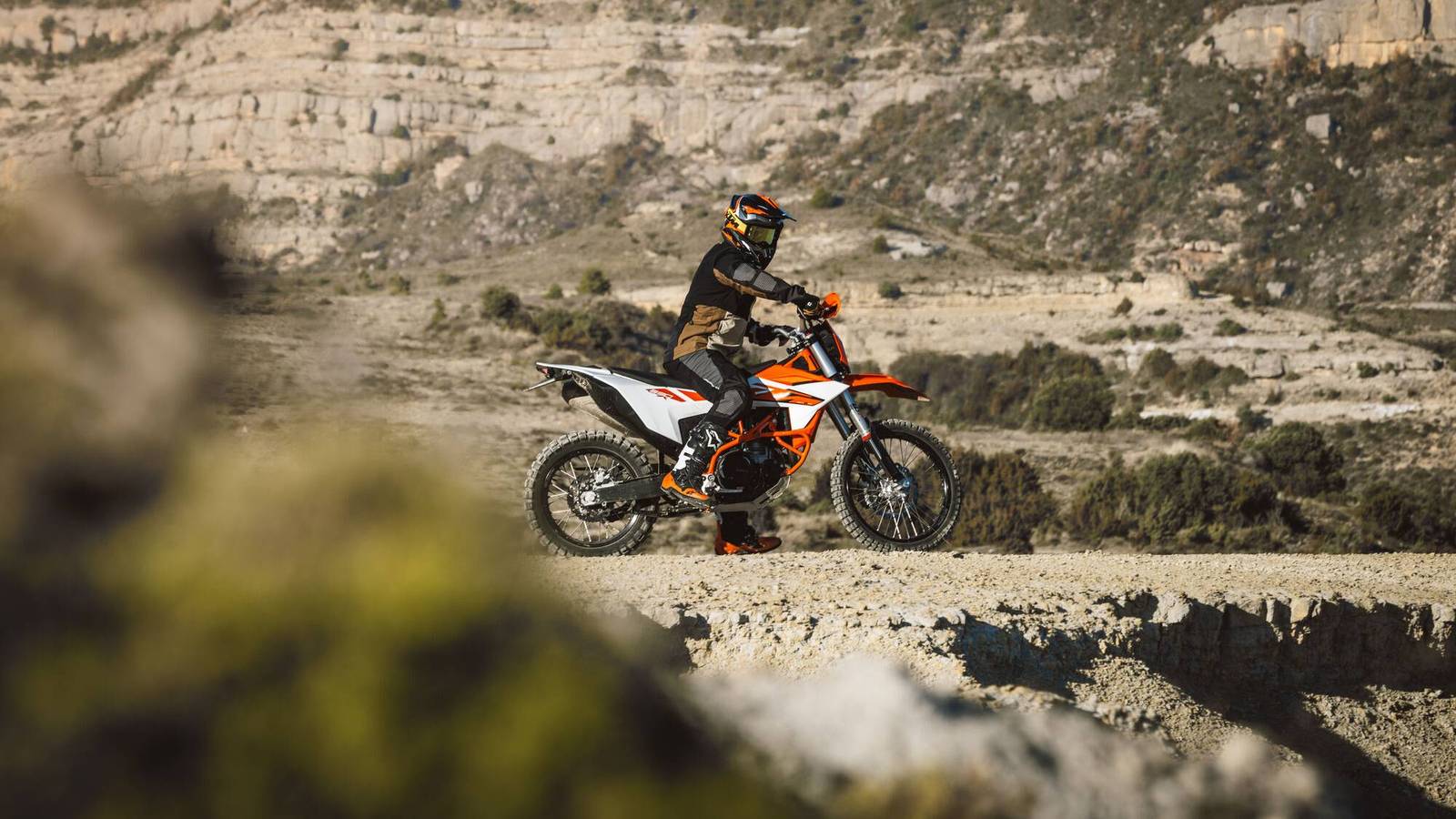 Una KTM 690 Enduro R in strada, con il motore acceso e la sella dura, mentre si percorre una strada aperta