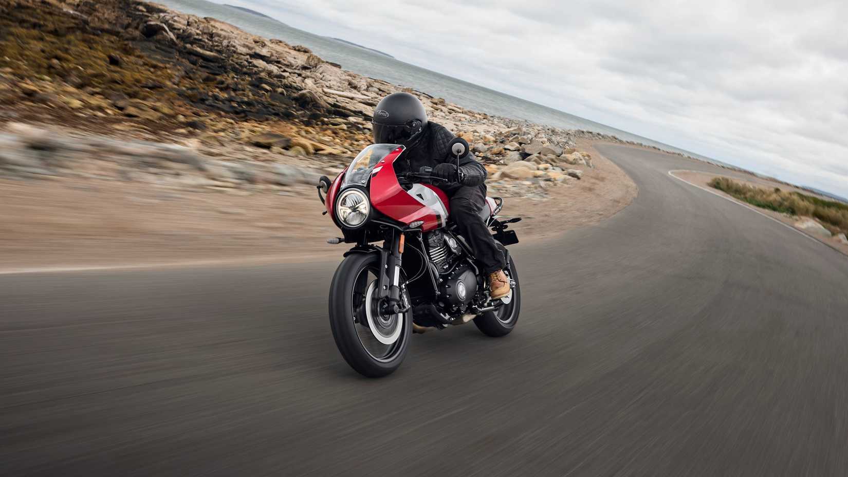 Red Silver 2026 Triumph Thruxton 400 fazendo uma curva perto da costa