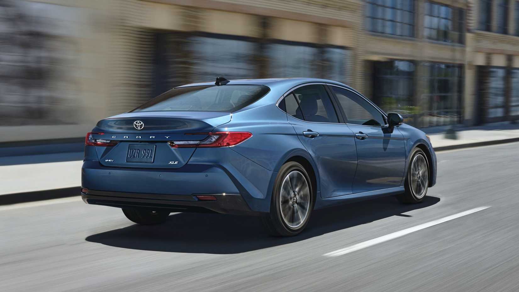 Rear 3/4 action shot of 2026 Toyota Camry Hybrid driving on road