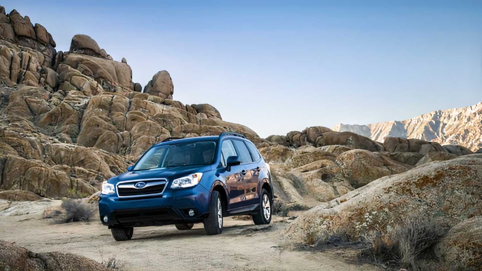 2014 Subaru Forester in blue being driven off-road