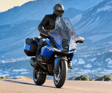 Piloto em uma BMW R 1300 RT 2026 viajando em uma estrada de montanha