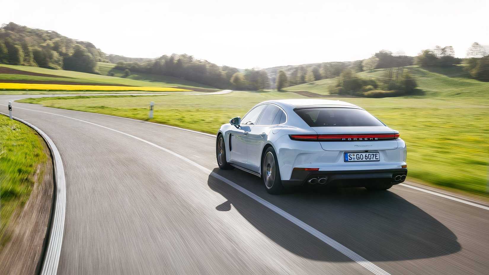 2026 Porsche Panamera 4 E-Hybrid driving rear 3/4 view