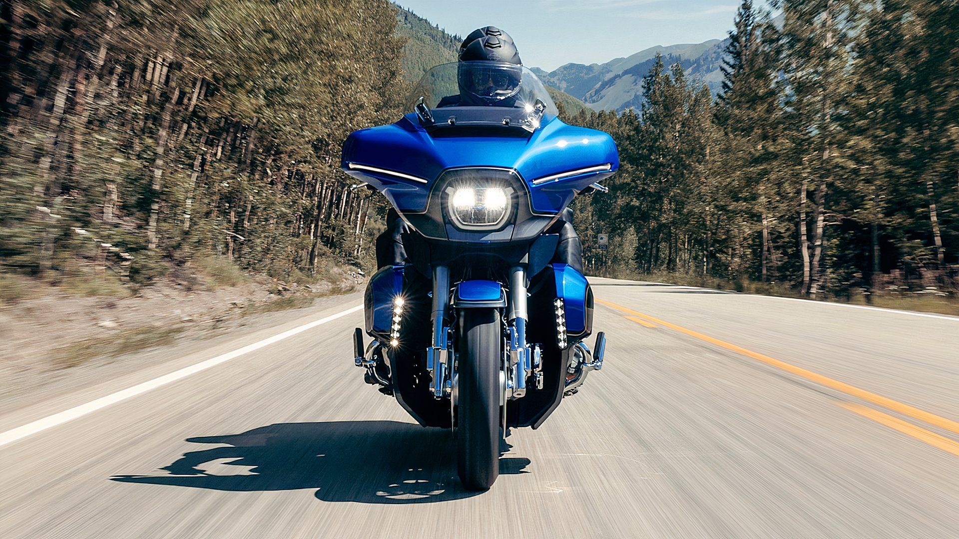 Foto de ação frontal da Harley-Davidson CVO Street Glide Limited 2026 dirigindo em uma estrada arborizada
