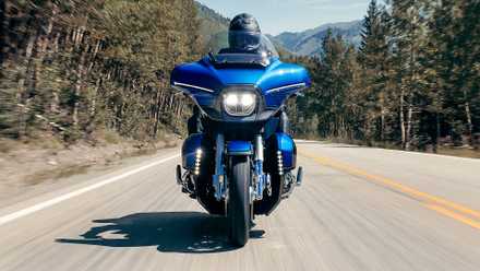 Foto de ação frontal da Harley-Davidson CVO Street Glide Limited 2026 dirigindo em uma estrada arborizada
