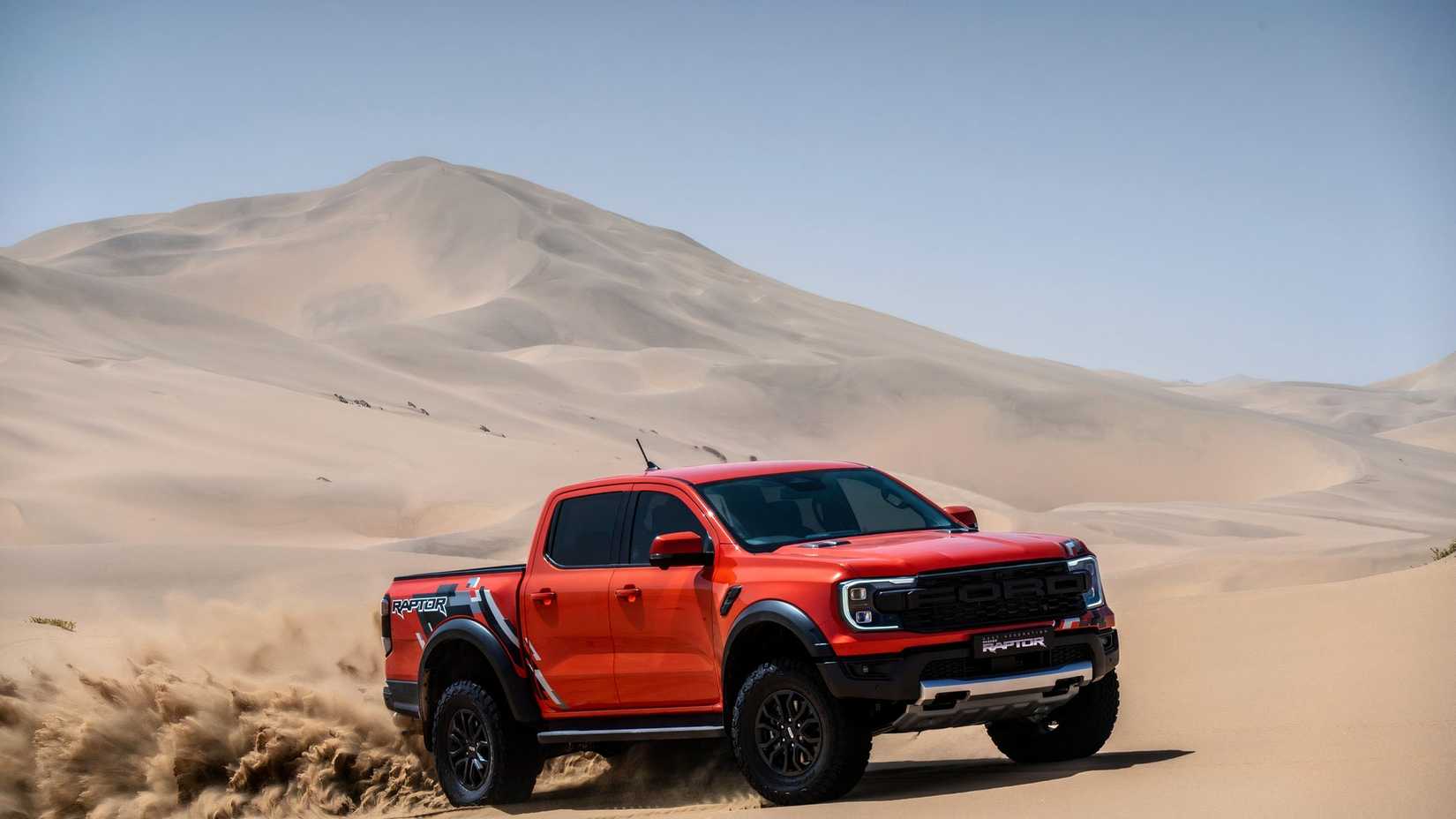Orange 2025 Ford Ranger Raptor Driving Through Desert