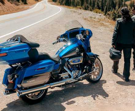 Piloto e passageiro ao lado de uma Harley-Davidson CVO Street Glide Limited 2026 estacionada na beira da estrada