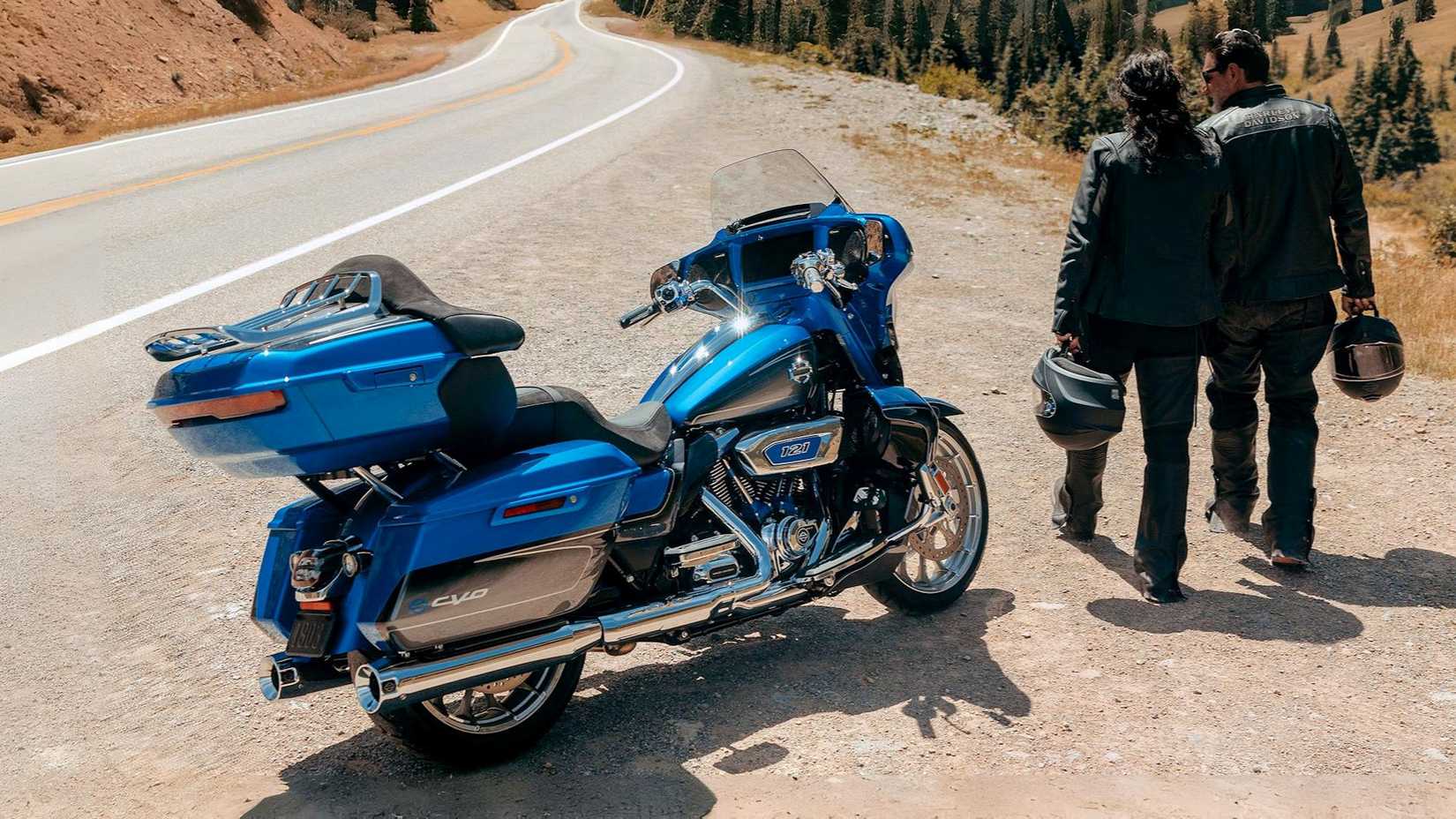 Piloto e passageiro ao lado de uma Harley-Davidson CVO Street Glide Limited 2026 estacionada na beira da estrada