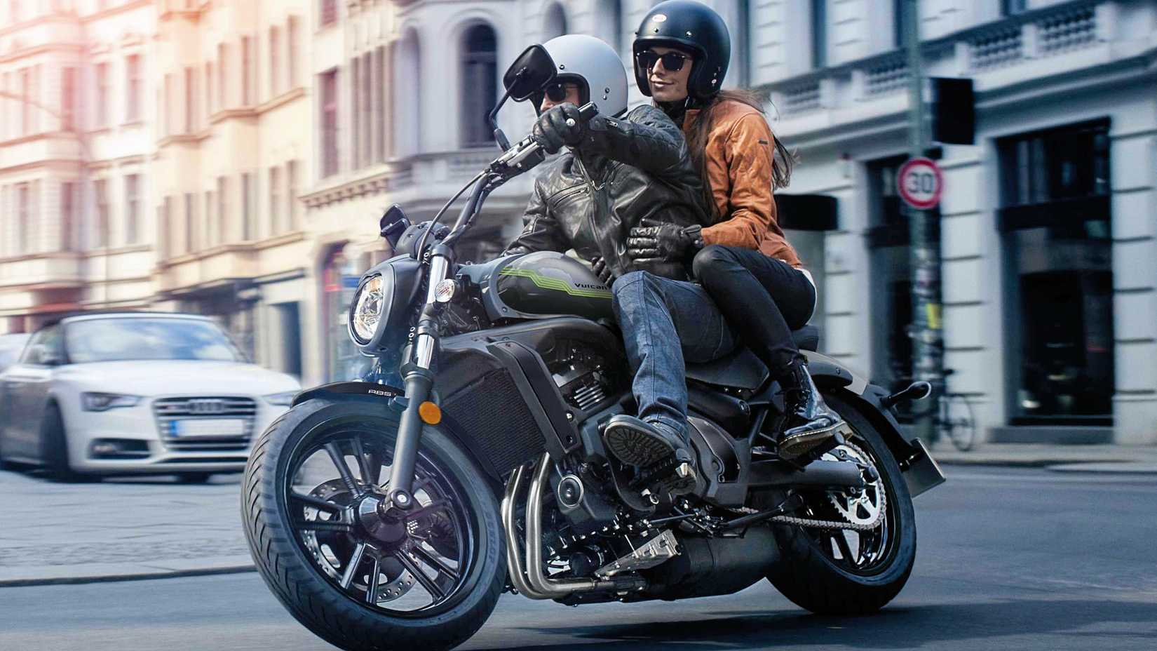 Rider and passenger on 2026 Kawasaki Vulcan S cruising through town