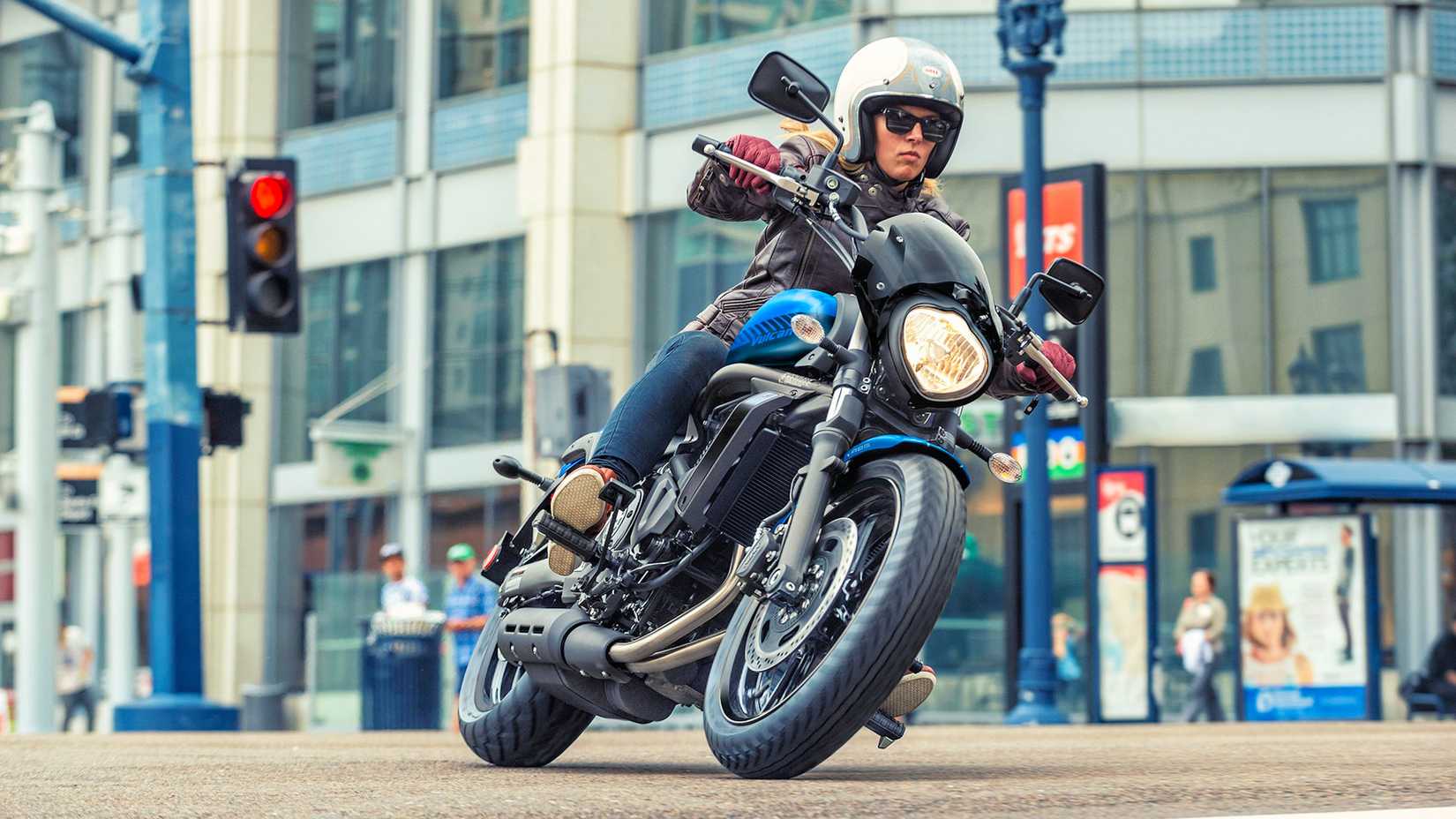 Piloto em 2026 Kawasaki Vulcan S cruzando pela cidade