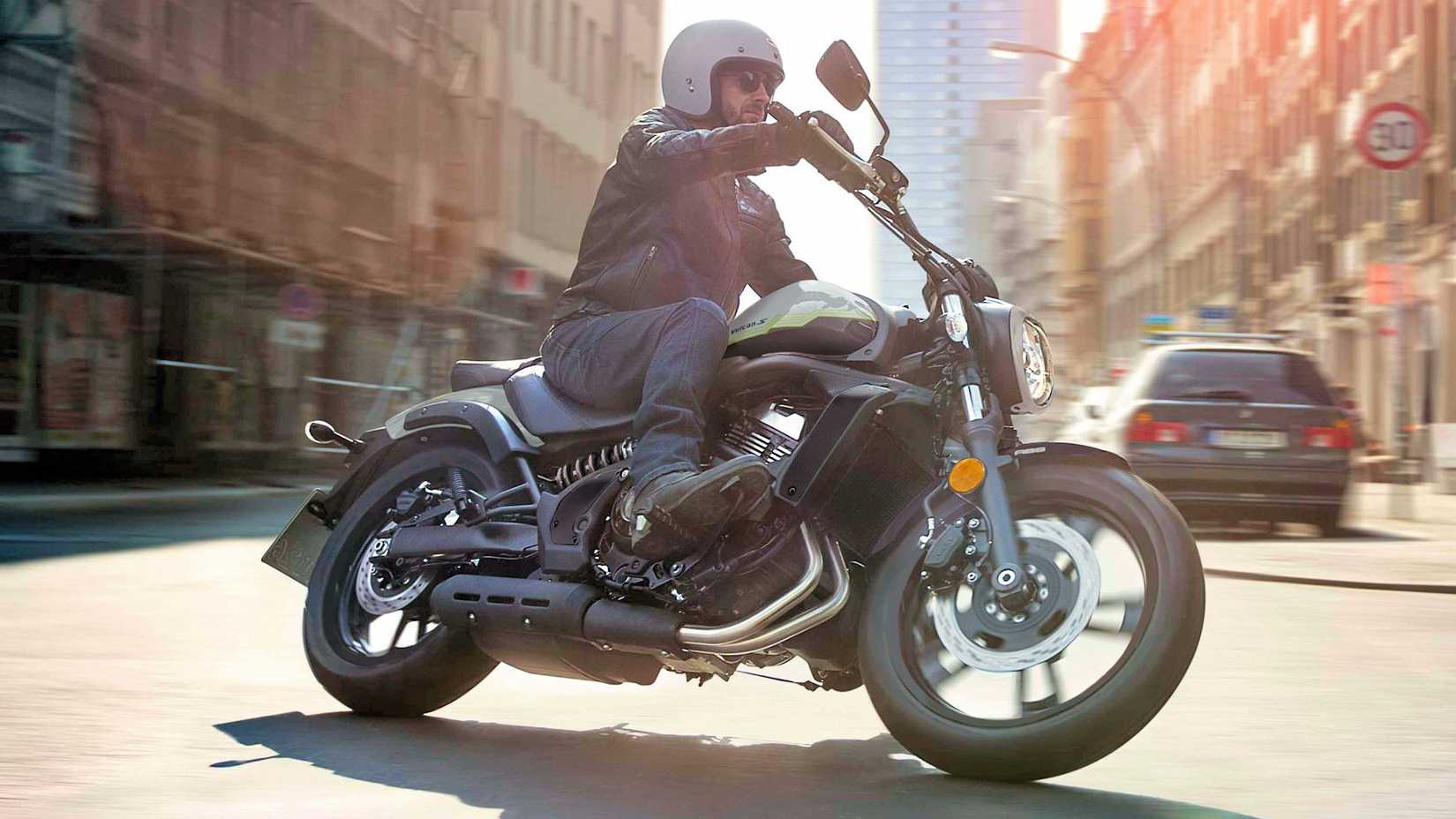 Piloto em 2026 Kawasaki Vulcan S cruzando pela cidade