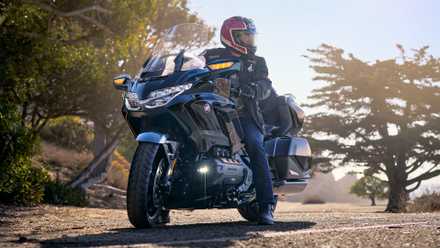 Piloto sentado em uma Honda Gold Wing Tour 2026 em frente a árvores