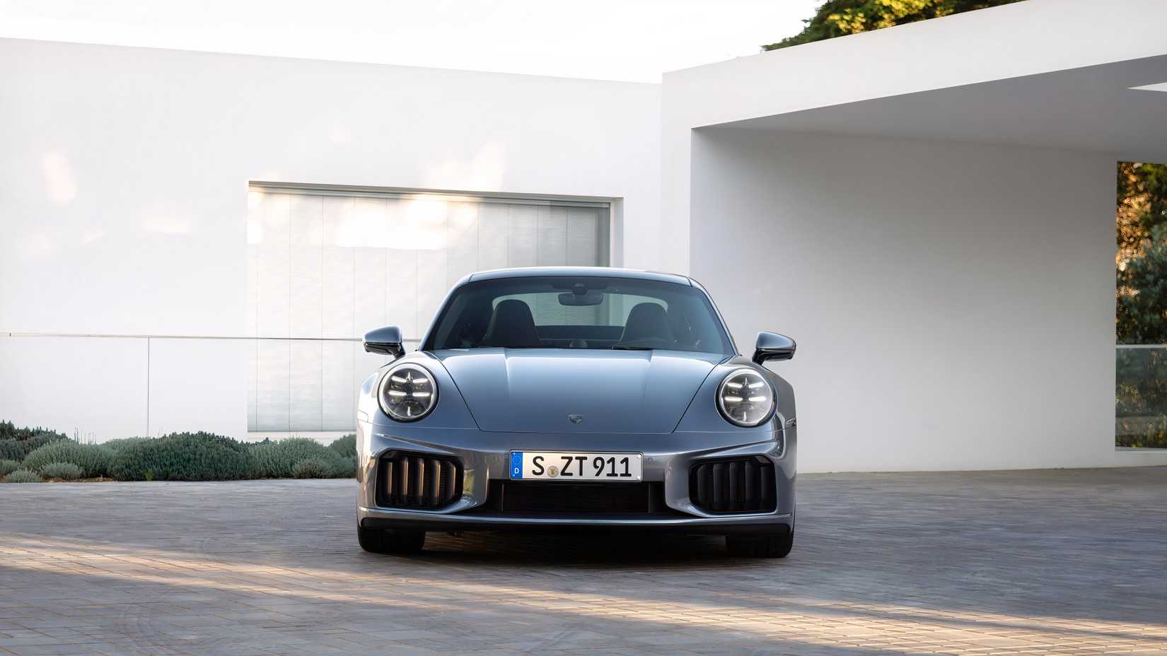 Foto frontal de um Porsche 911 Turbo S 2025 estacionado em frente à casa