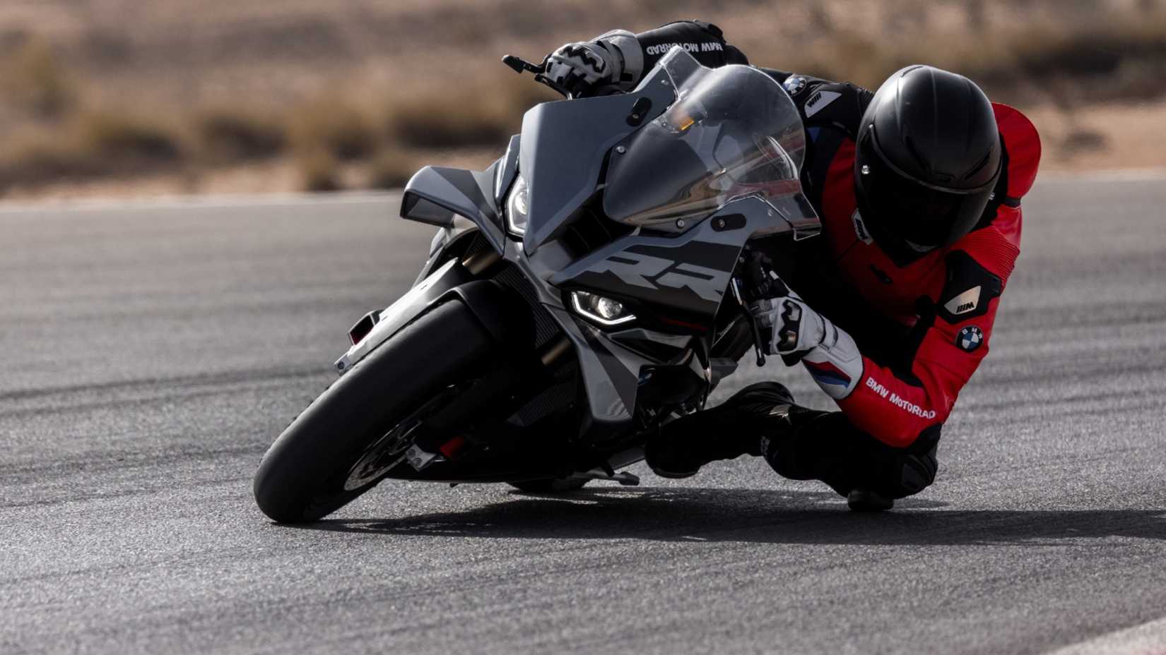 2025 BMW S 1000 RR em curva com o joelho do piloto abaixado em uma pista de corrida
