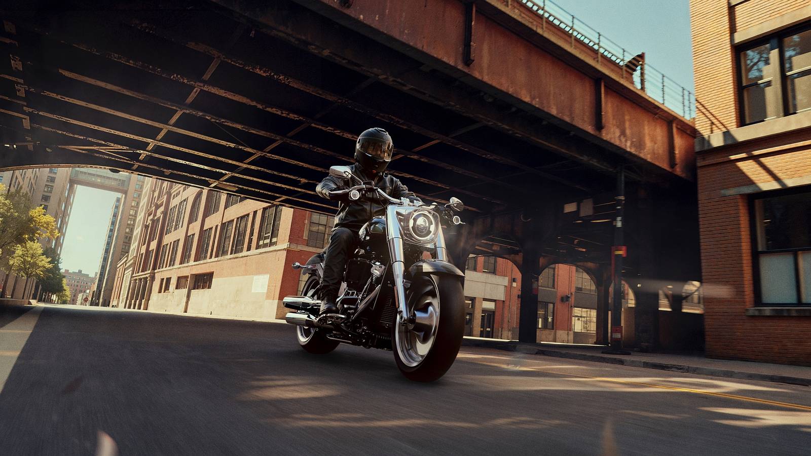 Un 2026 Harley-Davidson Fat Boy parcheggiato sotto un passaggio a livello, con un look retrò ma tecnologia moderna