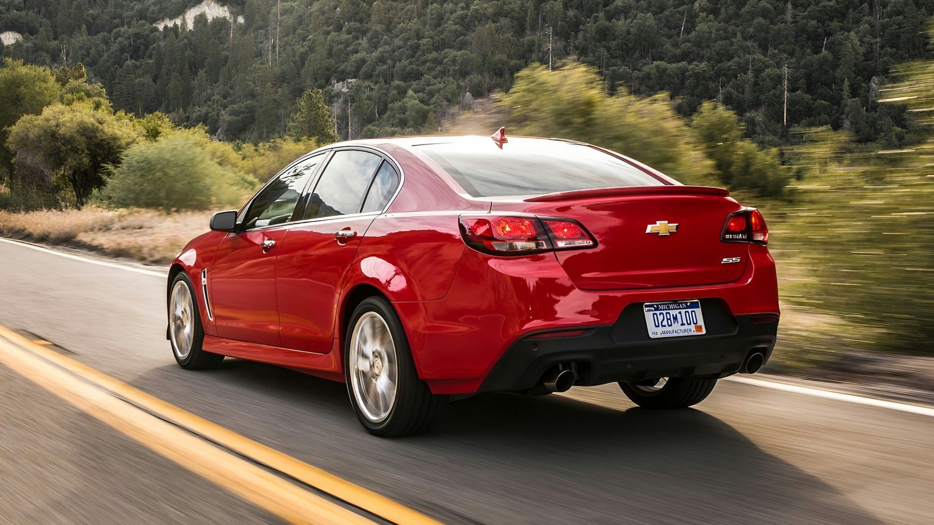 A red 2014 Chevrolet SS cruising down an open highway