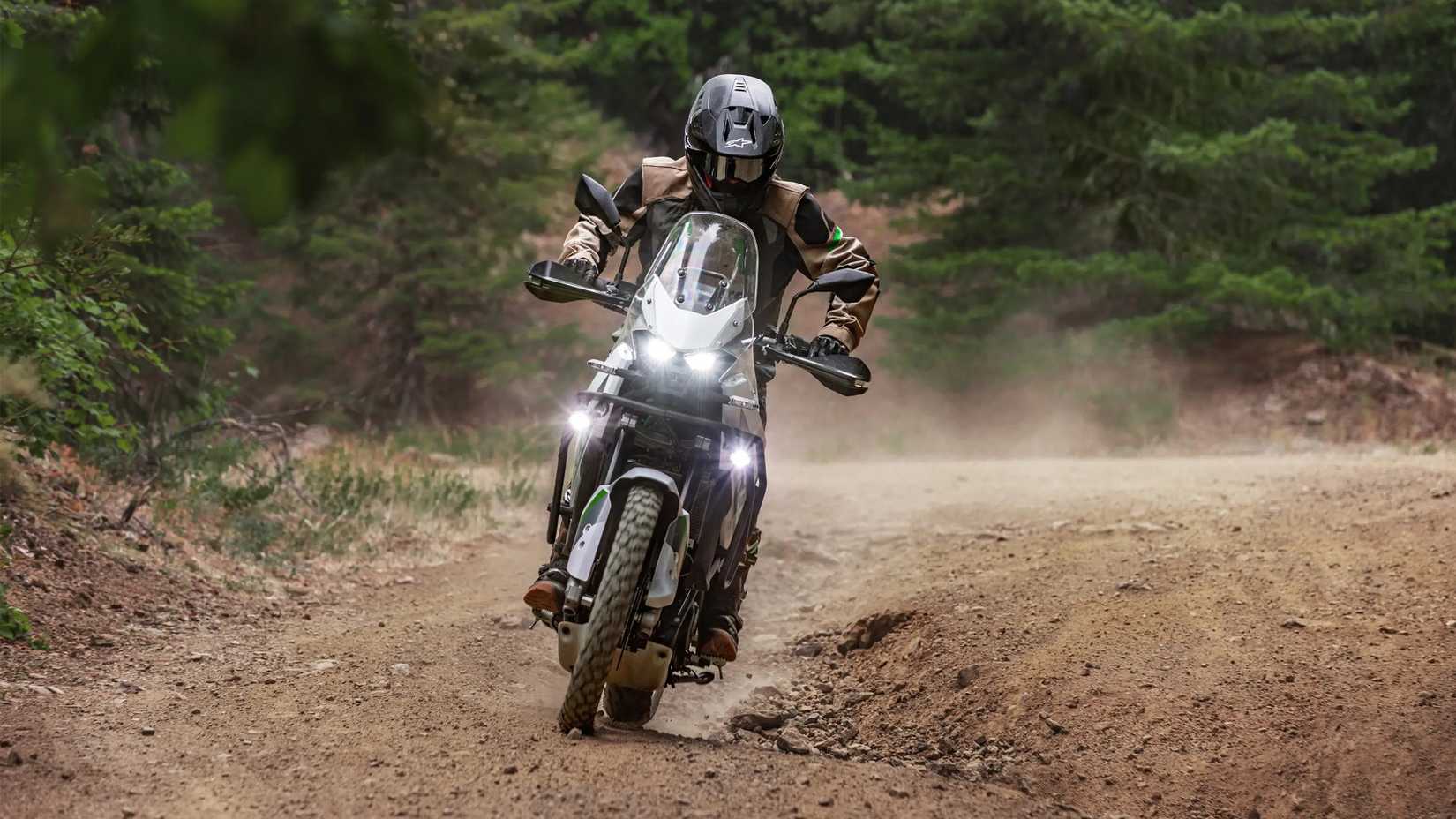 Kawasaki KLE500 SE branca atacando uma trilha de terra na floresta