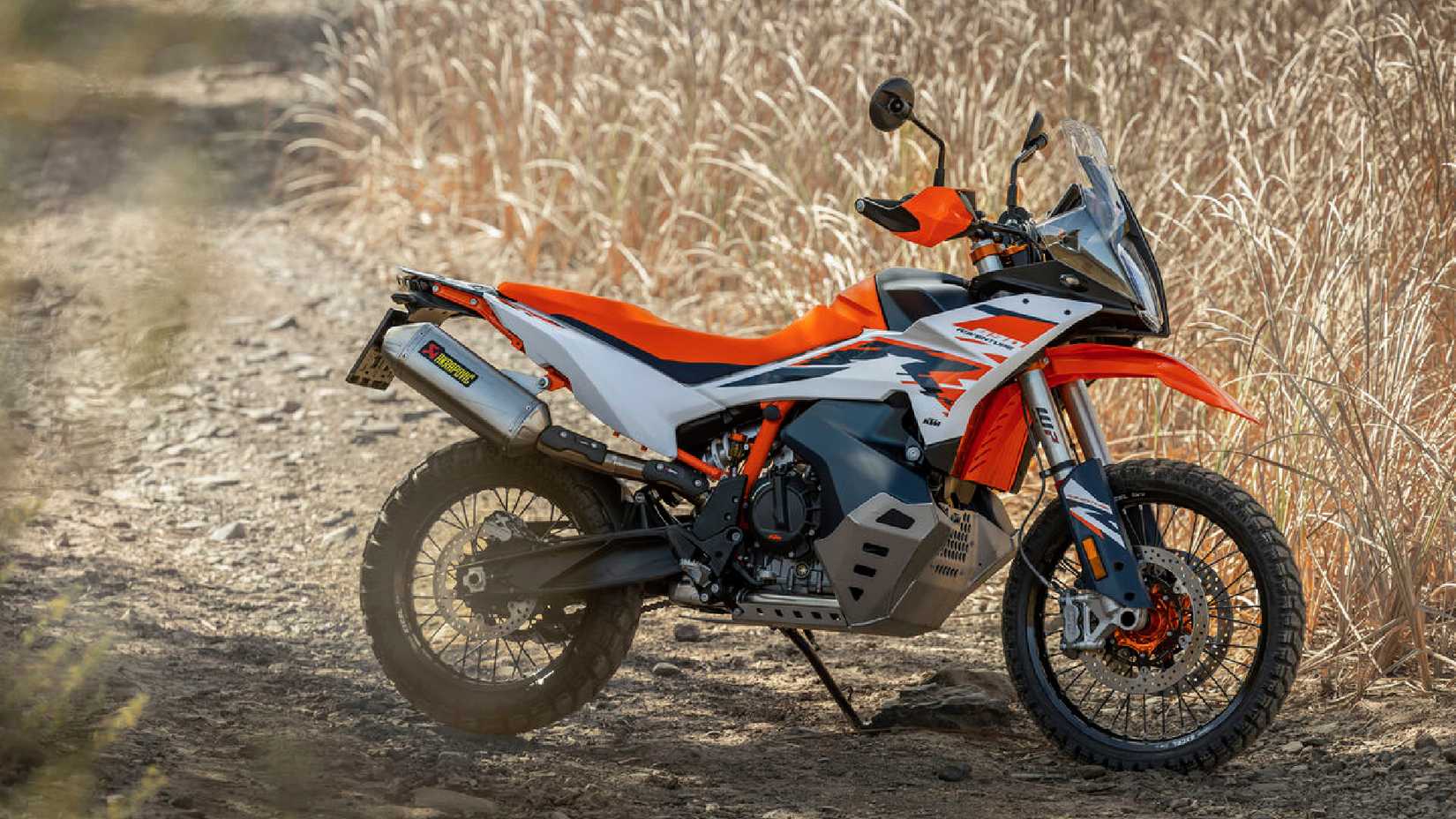 Foto estática de uma KTM 890 Adventure R estacionada em uma trilha de terra