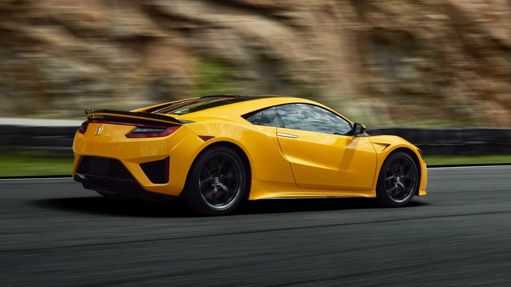 Foto traseira 3/4 de um Acura NSX 2020 em Indy Yellow Pearl dirigindo na estrada