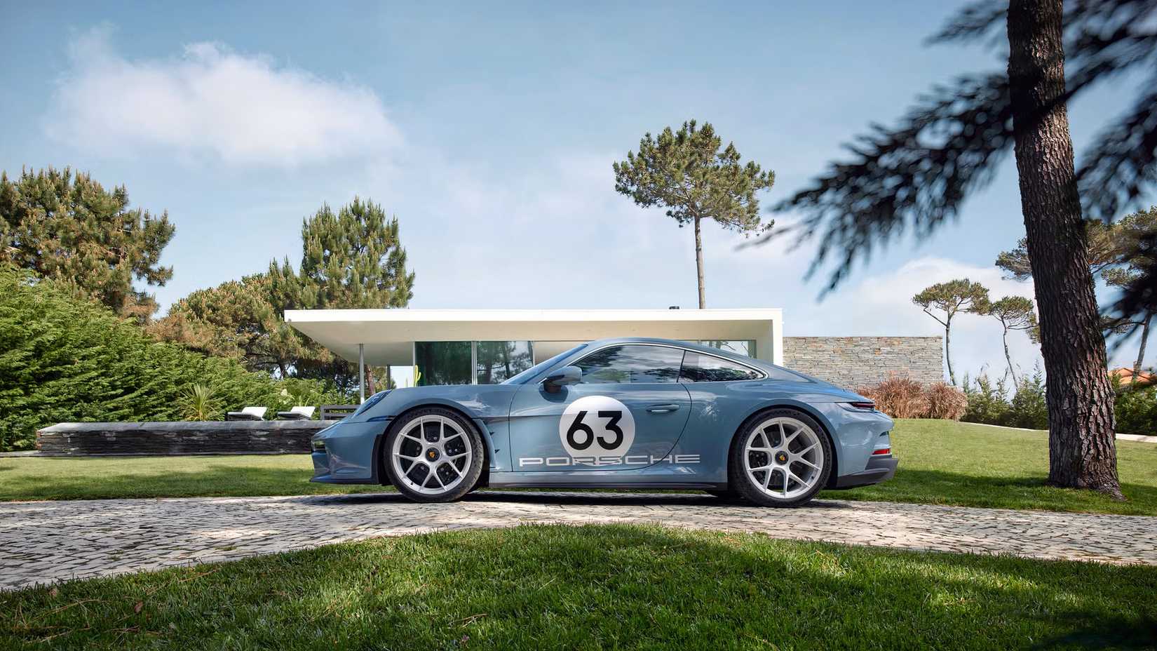 Foto lateral de um Porsche 911 S/T 2024 estacionado em frente à casa