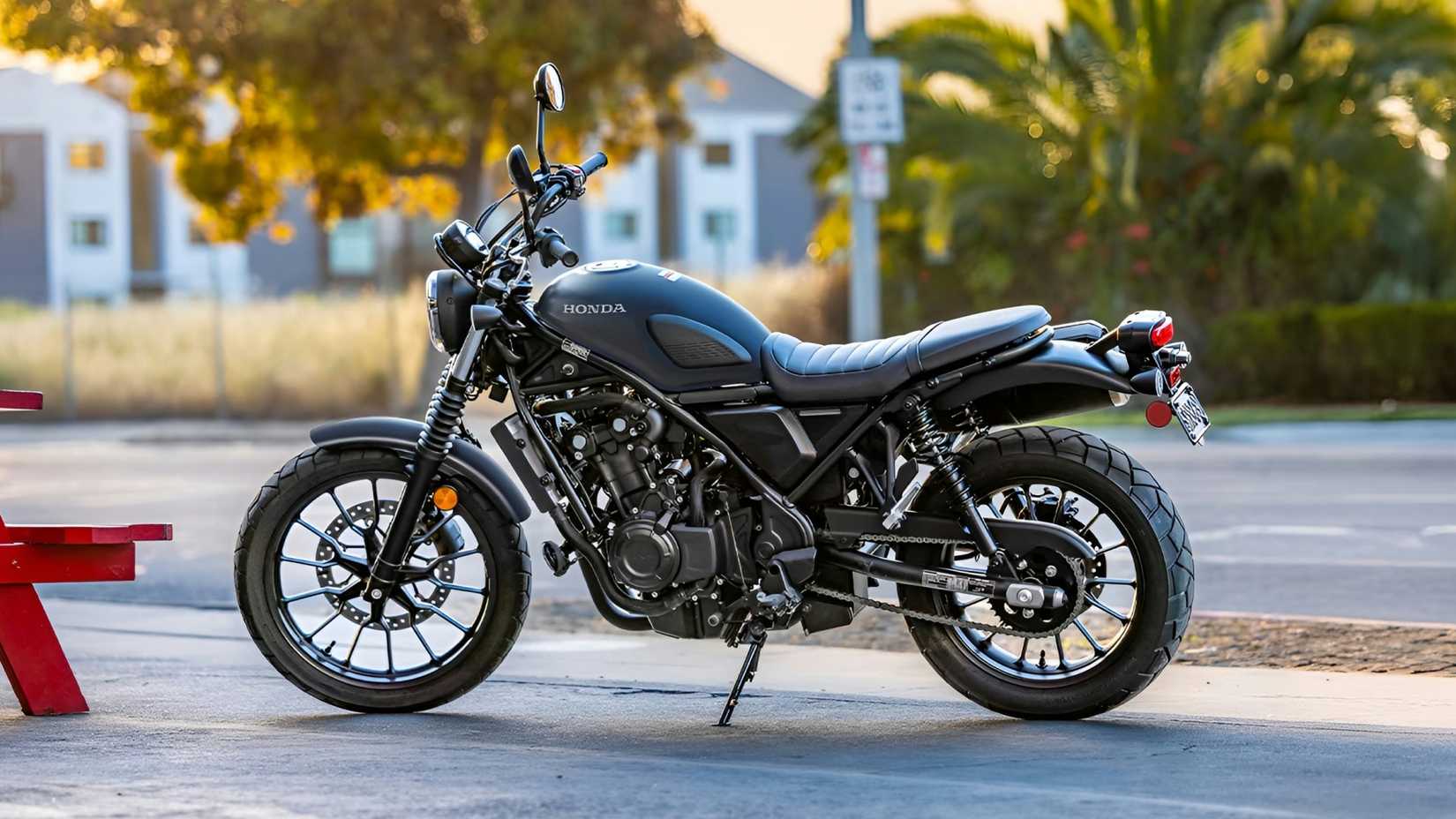 2026 Honda SCL500 em preto estacionado na beira da estrada da cidade, vista de perfil lateral