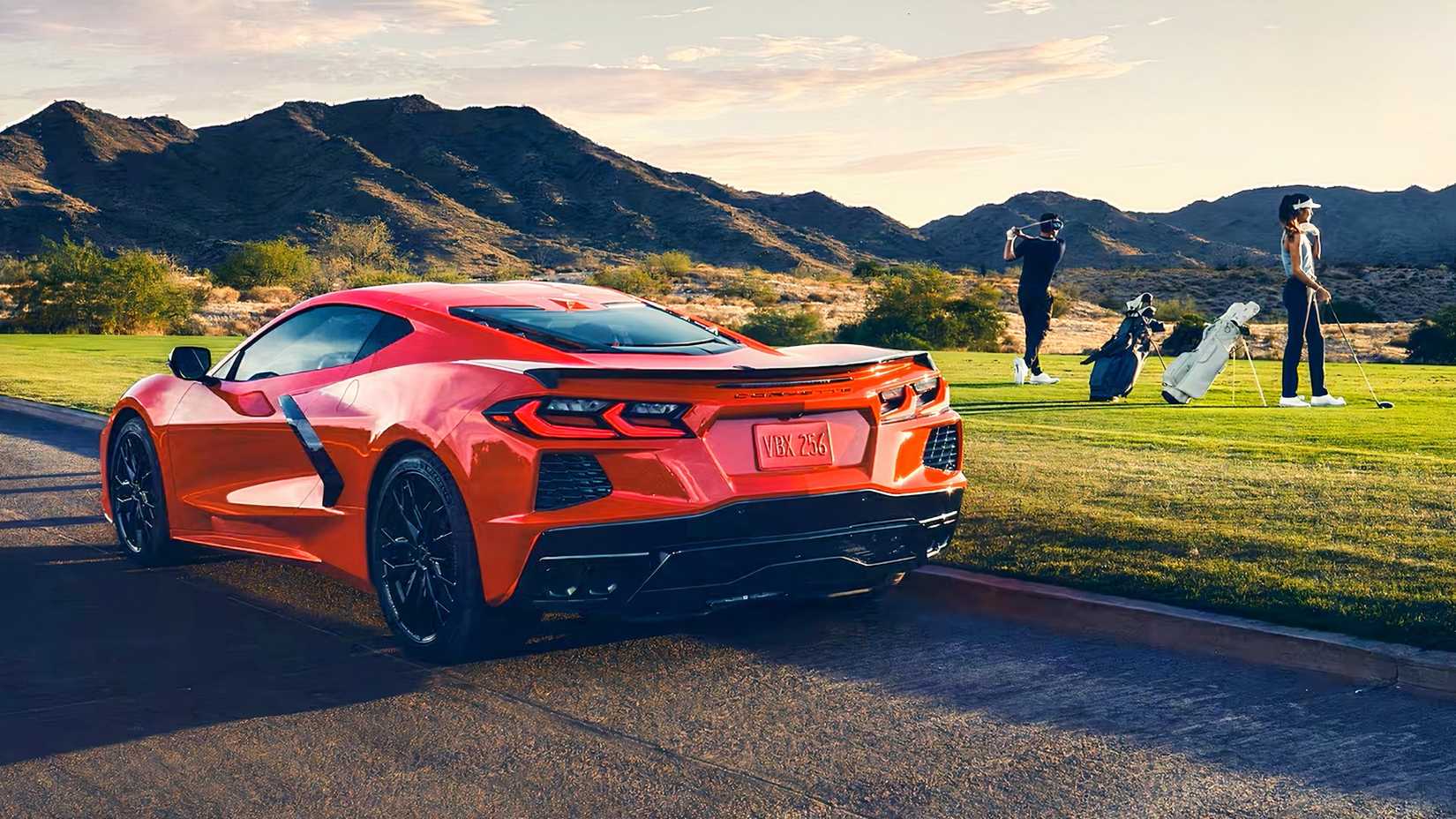 Foto da traseira de um Chevrolet Corvette Stingray 2026 vermelho em um campo de golfe