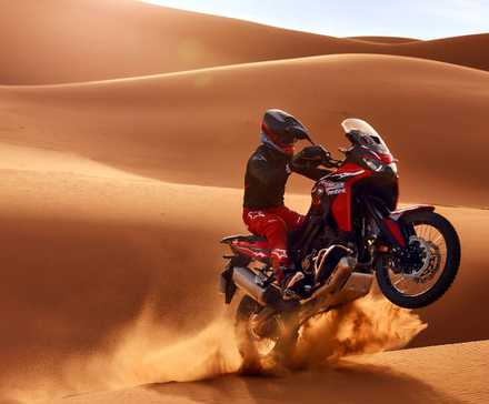 Foto de uma Honda Africa Twin 2026 pulando na areia