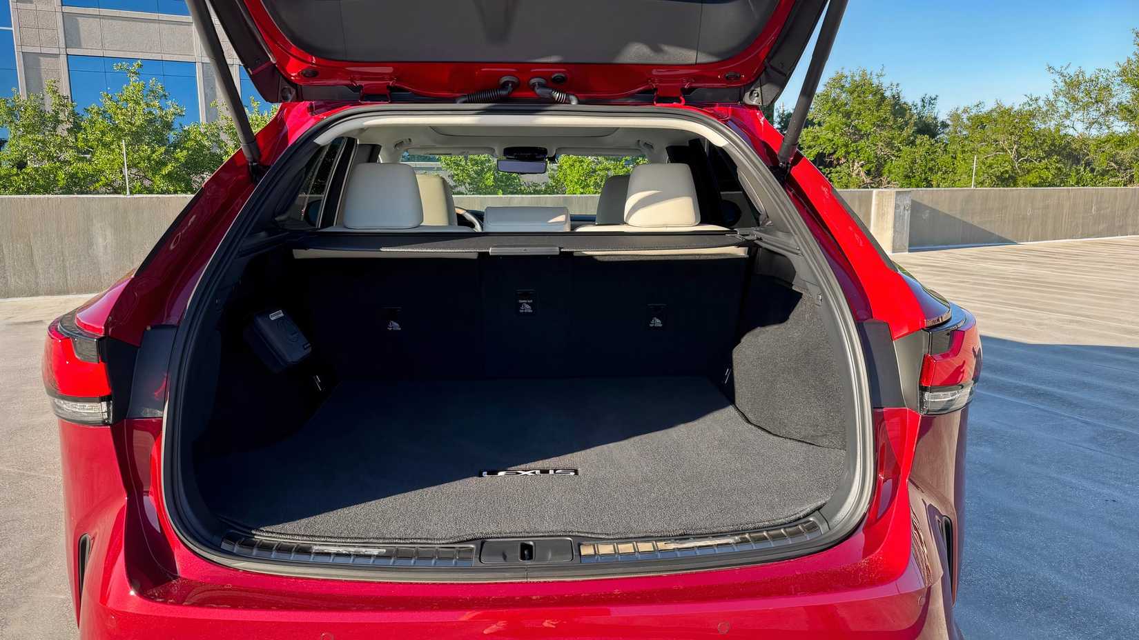 Foto do compartimento de carga de um Lexus RX 2026 vermelho com os bancos traseiros levantados