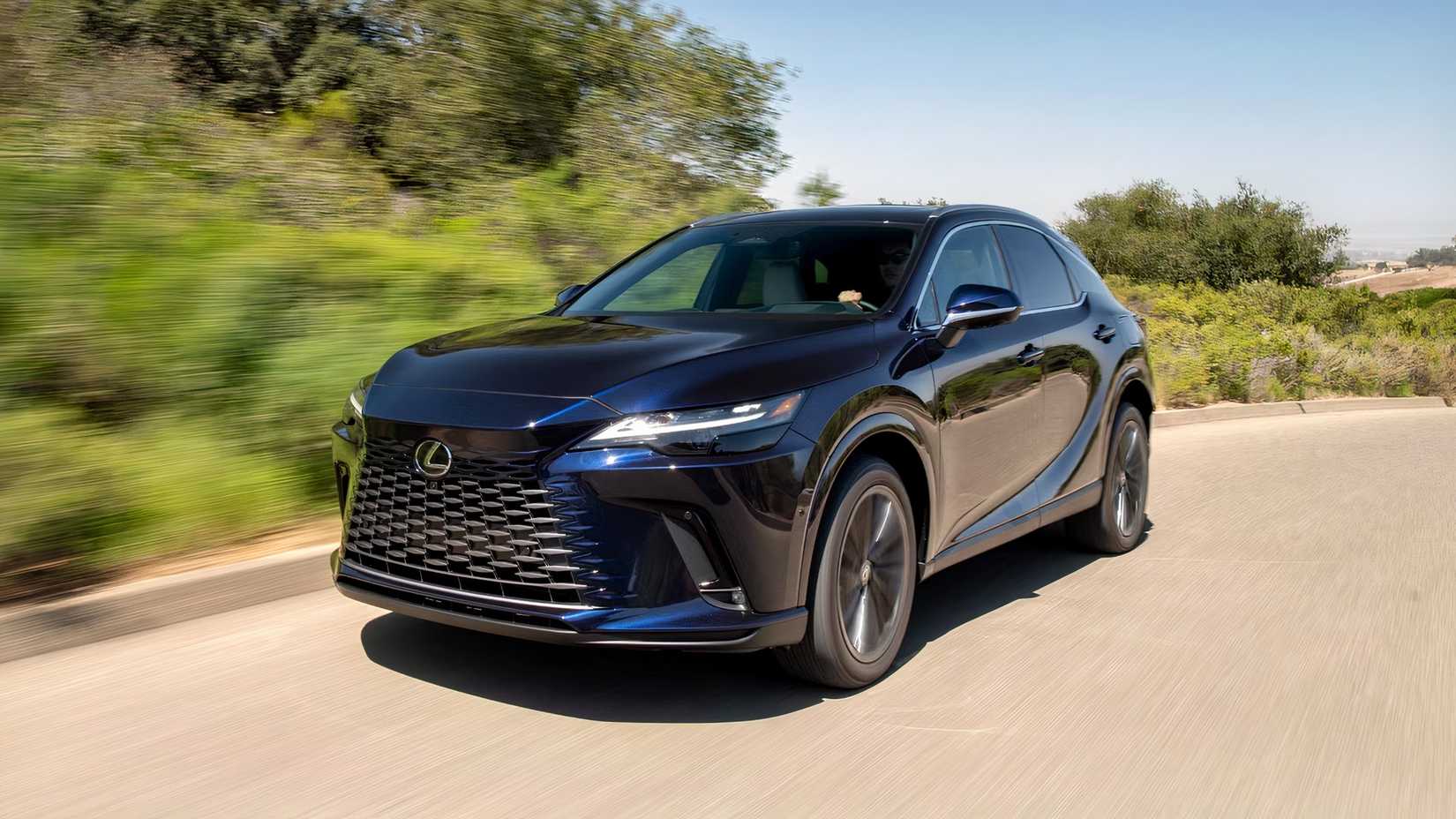 Front 3/4 shot of a blue 2026 Lexus RX driving down road