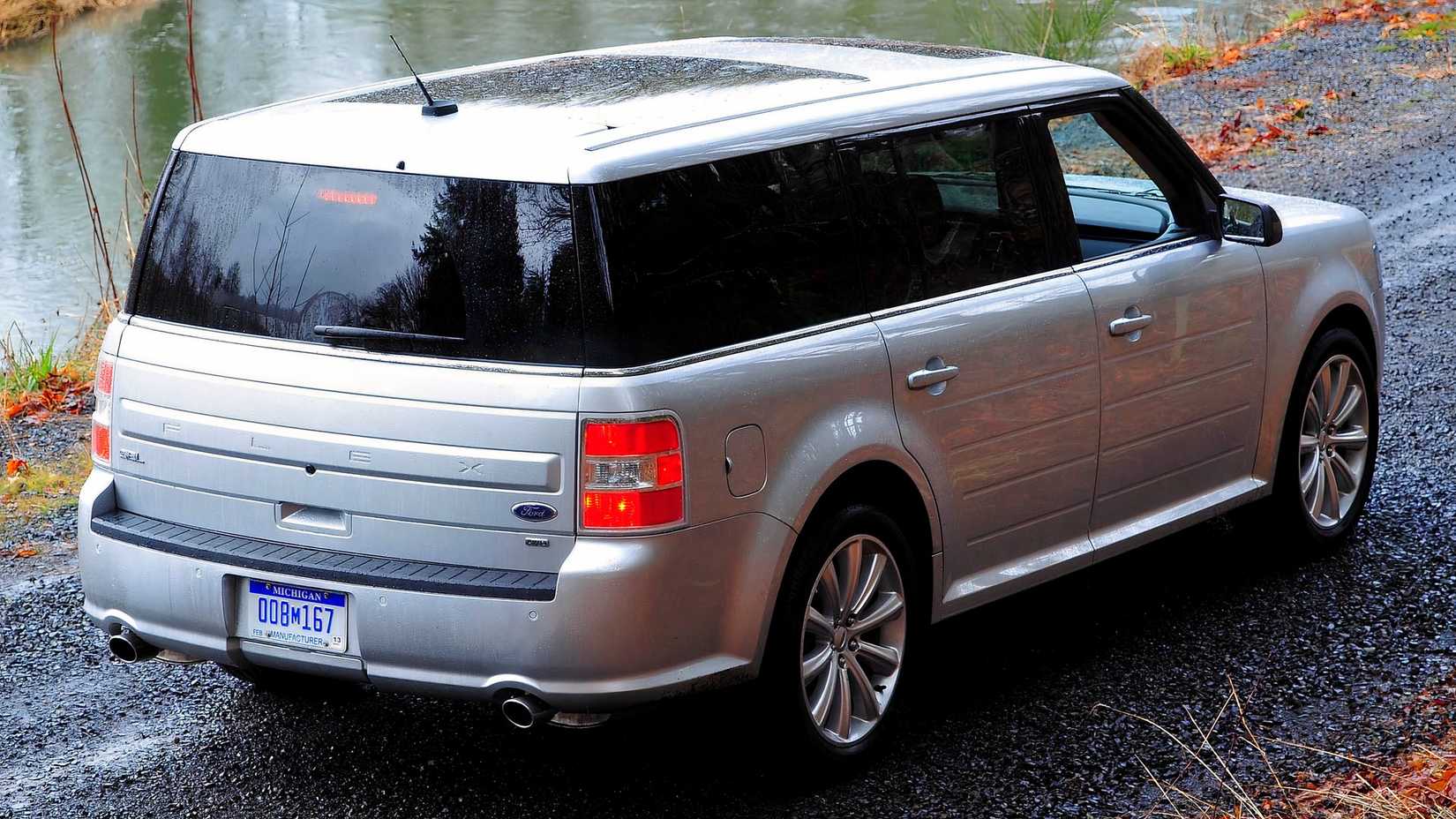 Rear 3/4 shot of a grey 2013 Ford Flex parked off-road