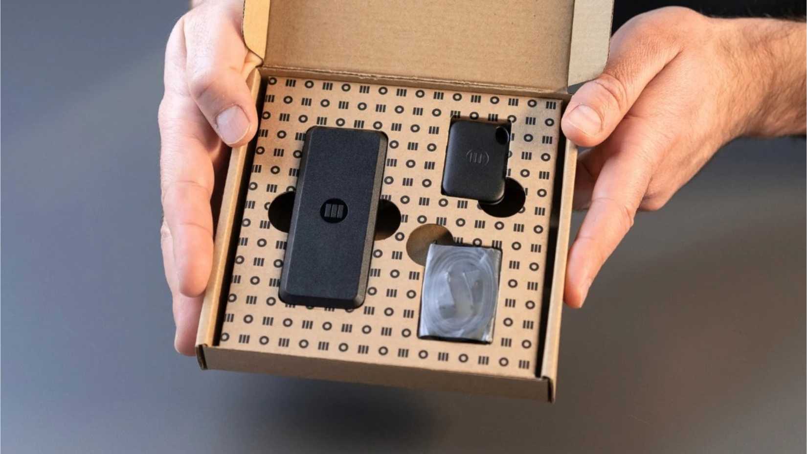 Rastreador GPS Monimoto 9 em sua caixa, com chaveiro dedicado e cabo de carregamento