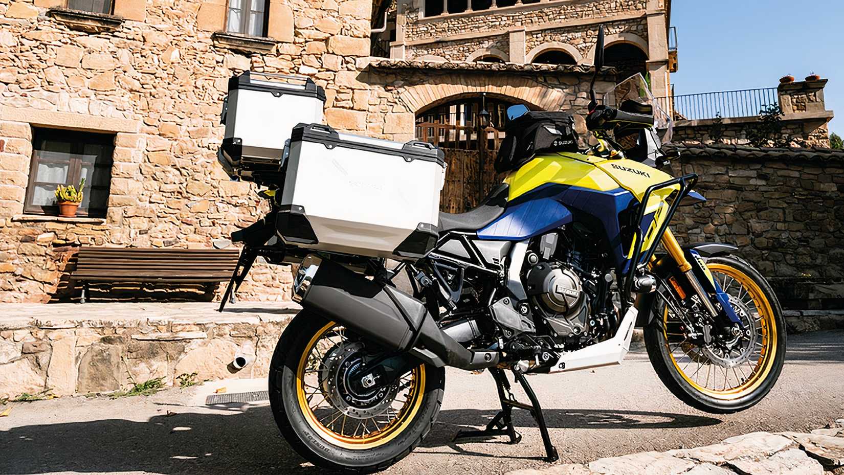 Suzuki V-Strom 800DE parked in front of a picturesque house