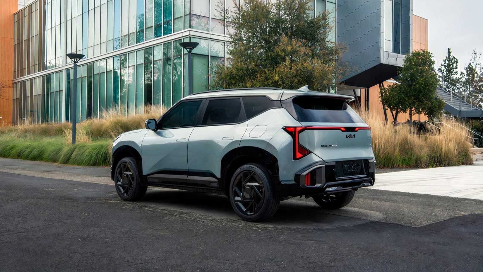 Foto lateral de um Kia Seltos Hybrid 2027 azul estacionado em frente ao prédio