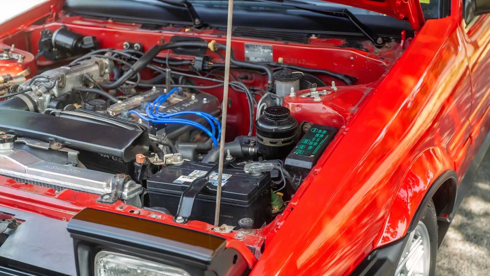 1986 Toyota Corolla GT-S em vermelho com capô aberto mostrando motor