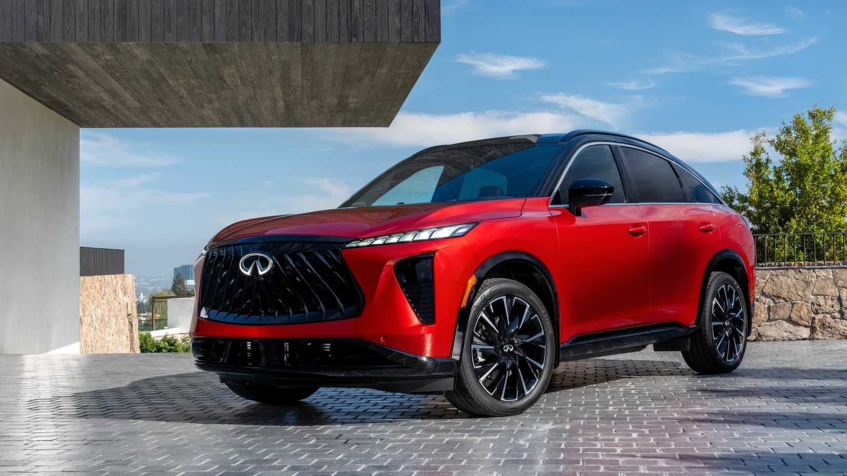 Front 3/4 shot of a red 2027 Infiniti QX65 parked in front of house