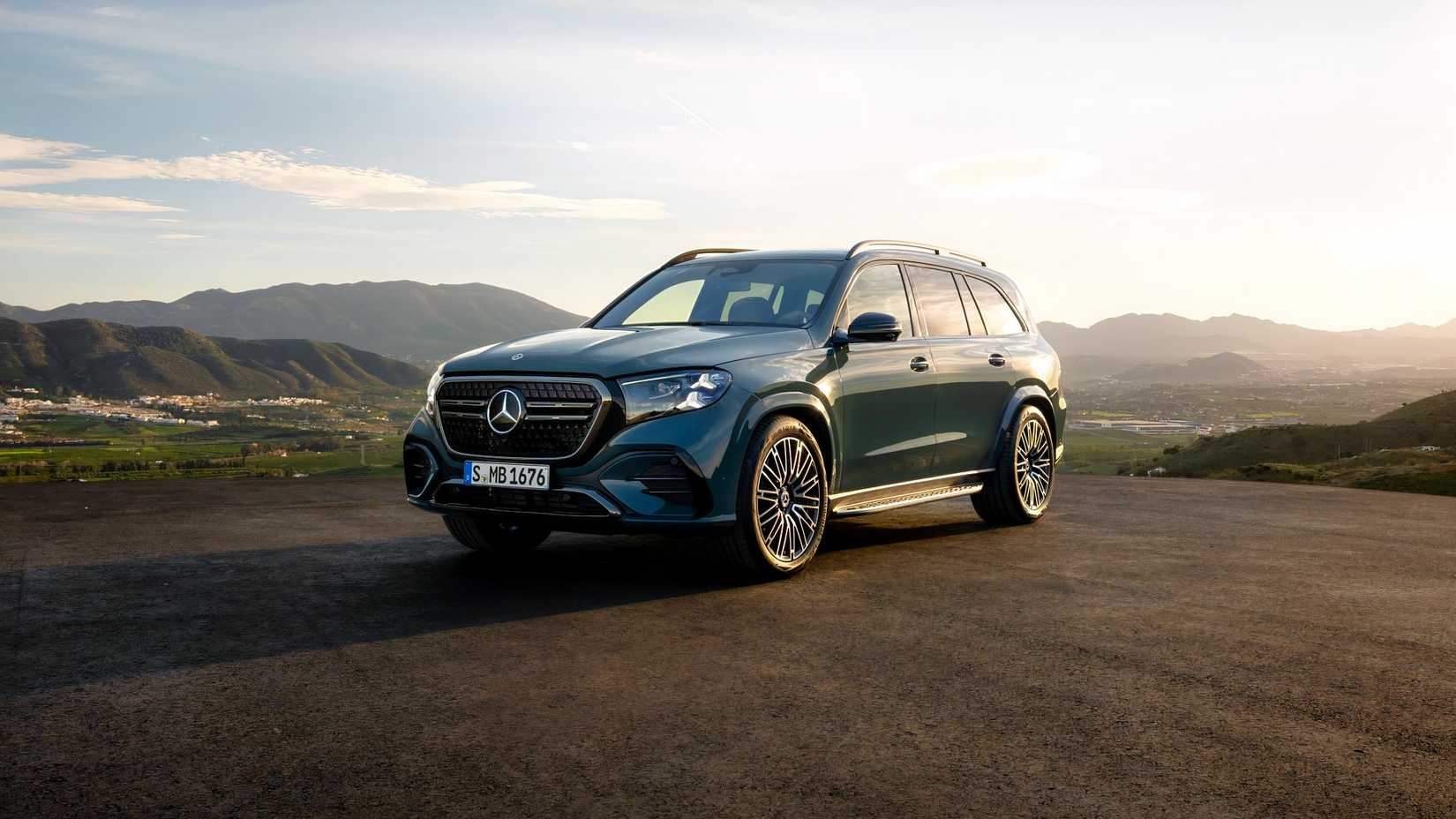 Front 3/4 shot of a green 2027 Mercedes-Benz GLS parked in front of mountains