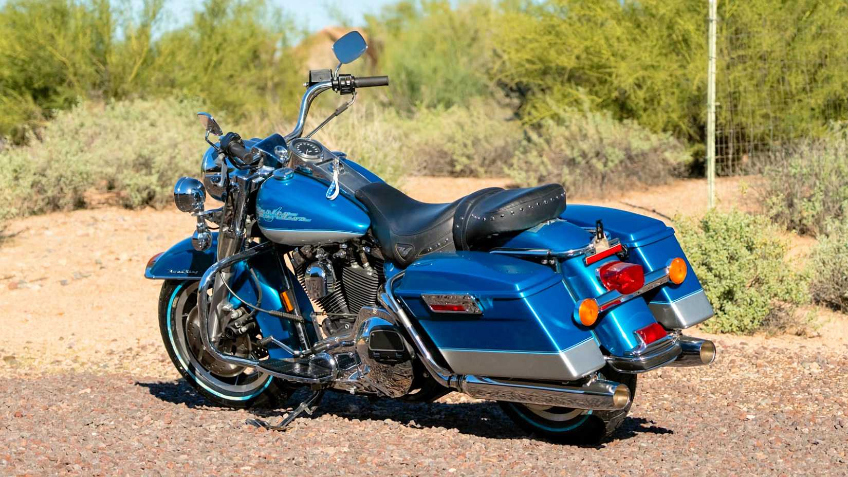 Foto traseira estática da Harley-Davidson Road King 1994 estacionada em uma estrada de cascalho