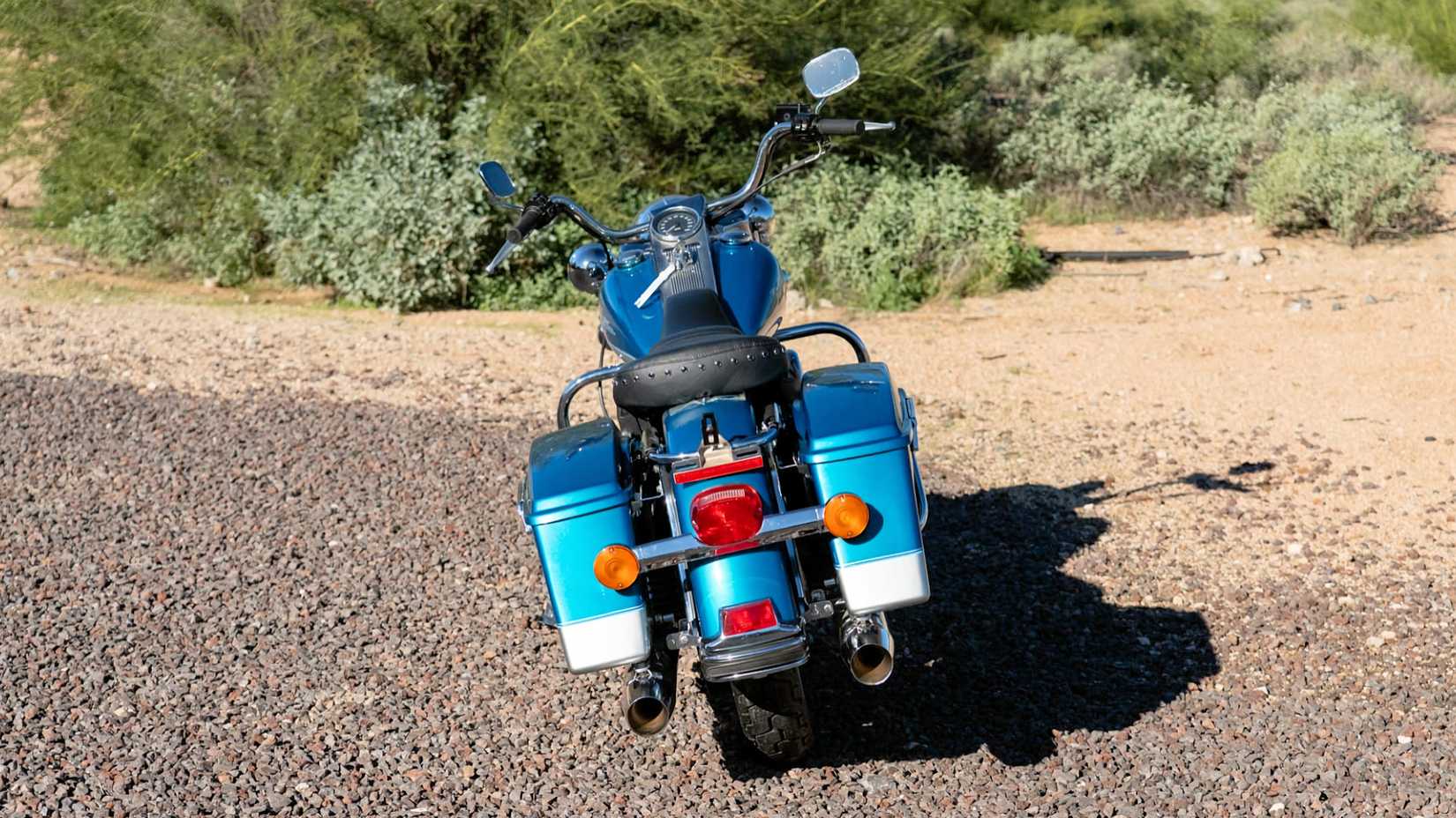 Tiro traseiro estático da Harley-Davidson Road King de 1994 estacionado em uma estrada de cascalho