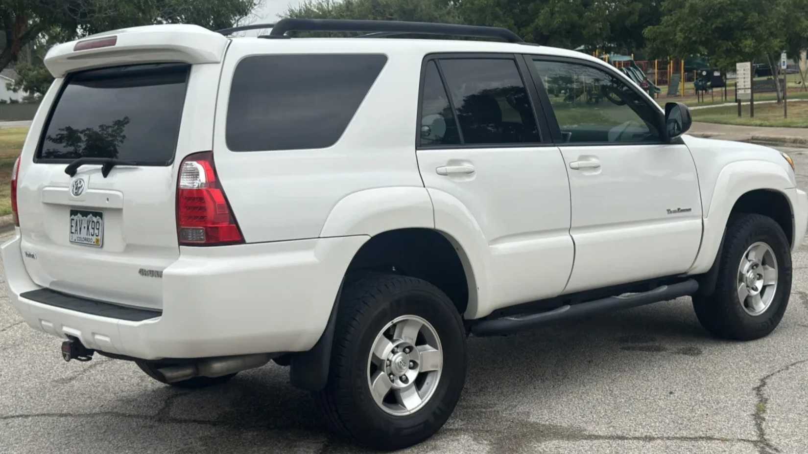 Rear 3/4 shot of a white 2009 Toyota 4Runner parked in a lot