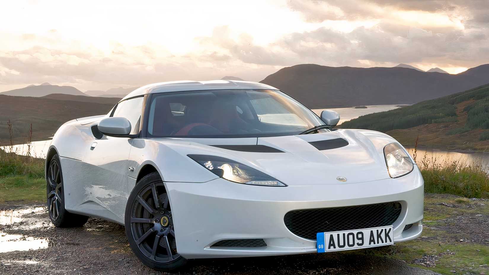 Foto frontal 3/4 de um Lotus Evora 2009 estacionado em cascalho