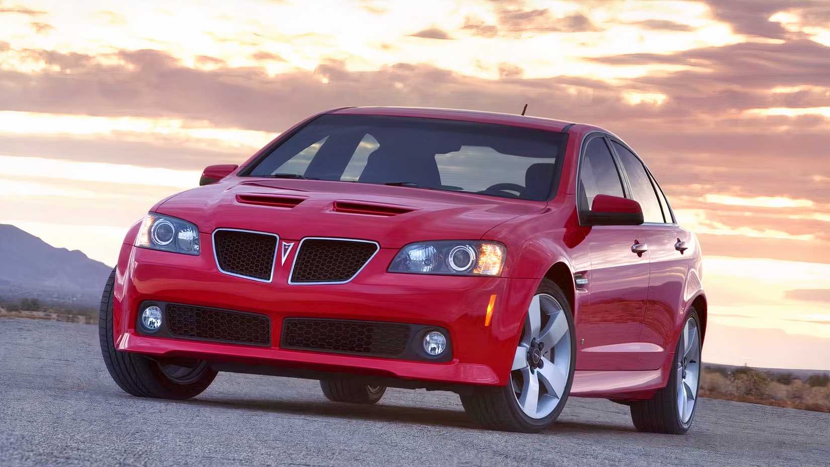 Pose em ângulo frontal vermelho 2009 Pontiac G8 com fundo do pôr do sol