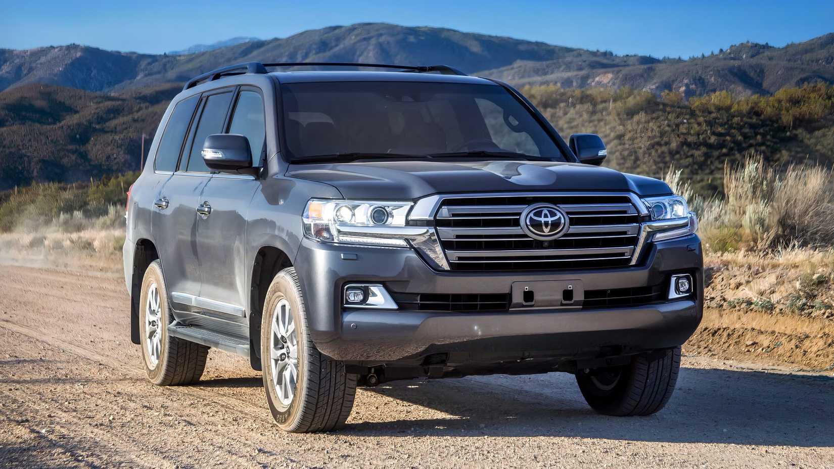 Foto frontal de um Toyota Land Cruiser 2021 estacionado em uma estrada de terra