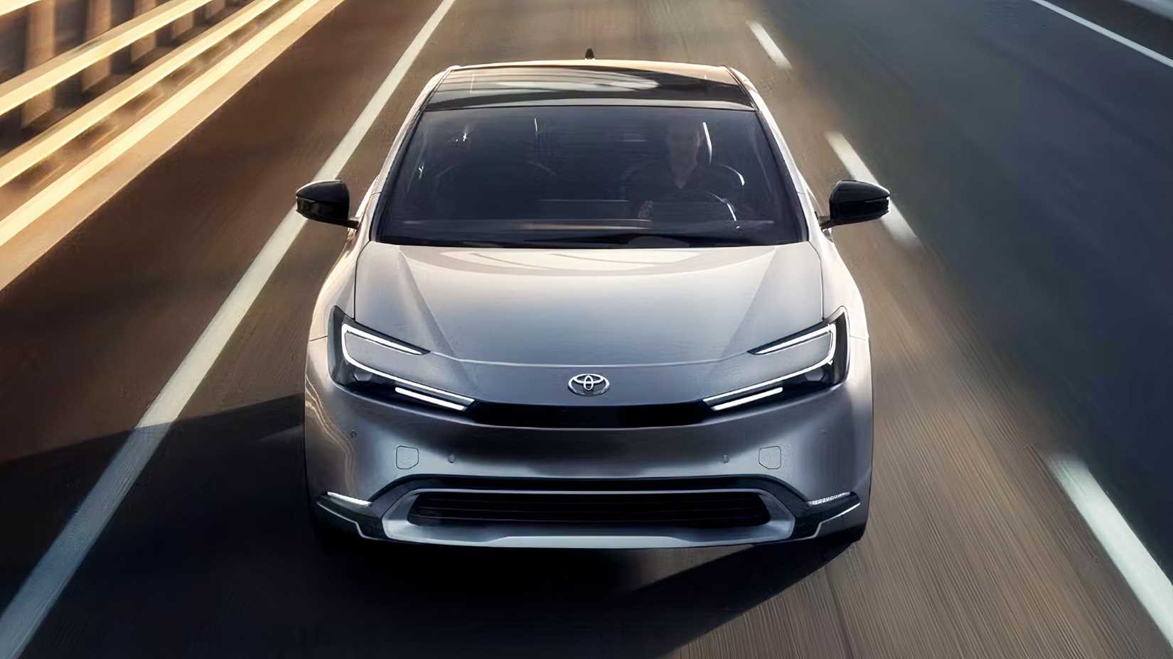 Front shot of a 2023 Toyota Prius driving down the road