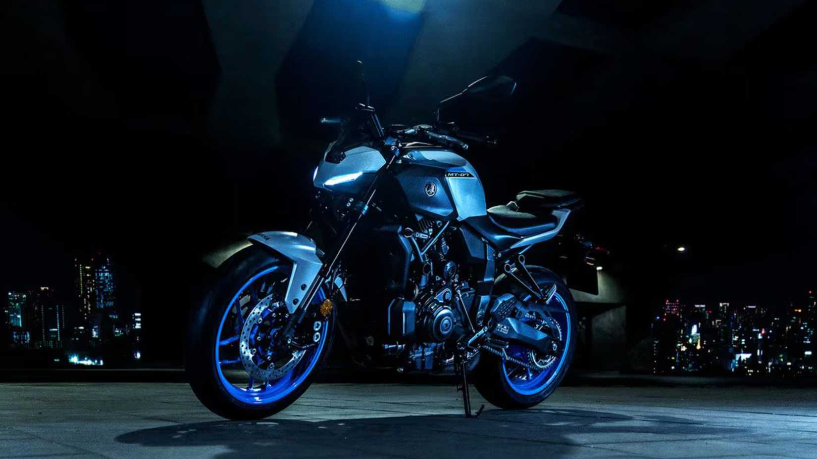Foto frontal da Yamaha MT-07 2025 em um estacionamento escuro