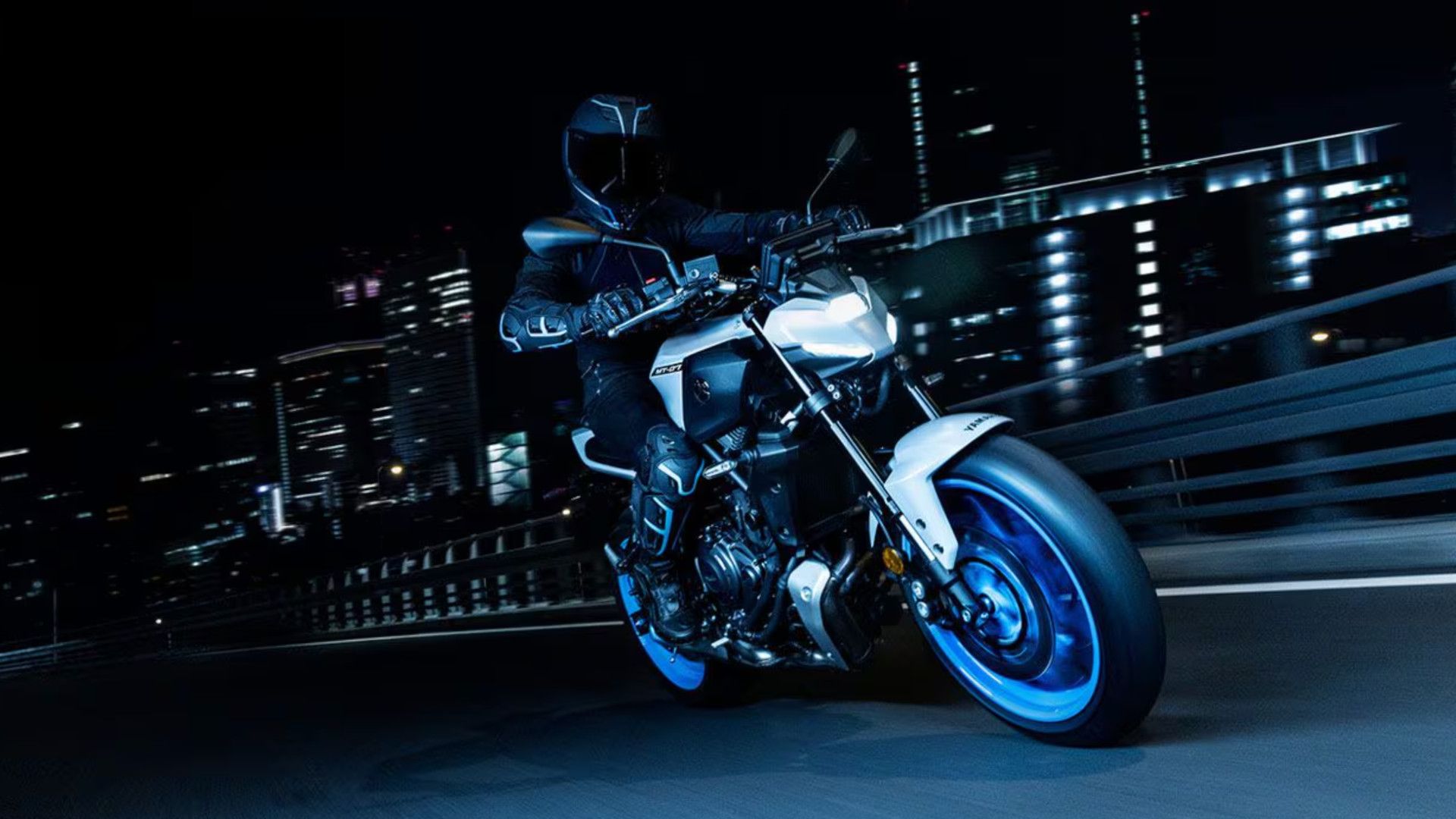 Piloto em uma Yamaha MT-07 2025 em uma ponte em uma cidade à noite