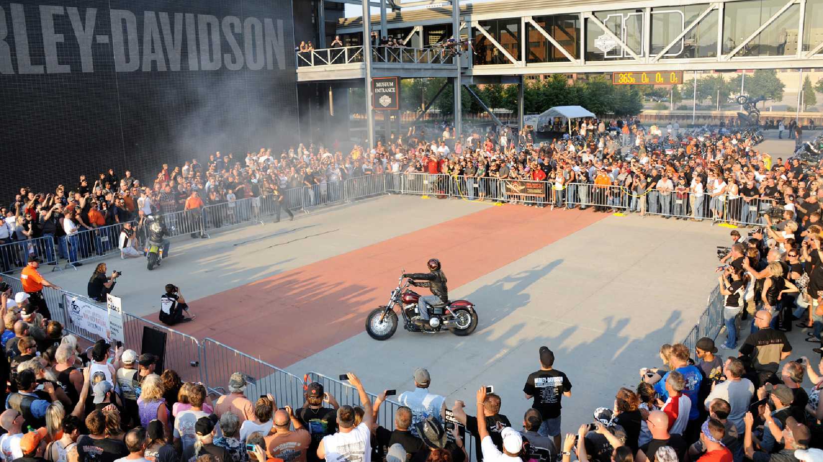 Aerial image of an audience gathered around a Harley stunt rider