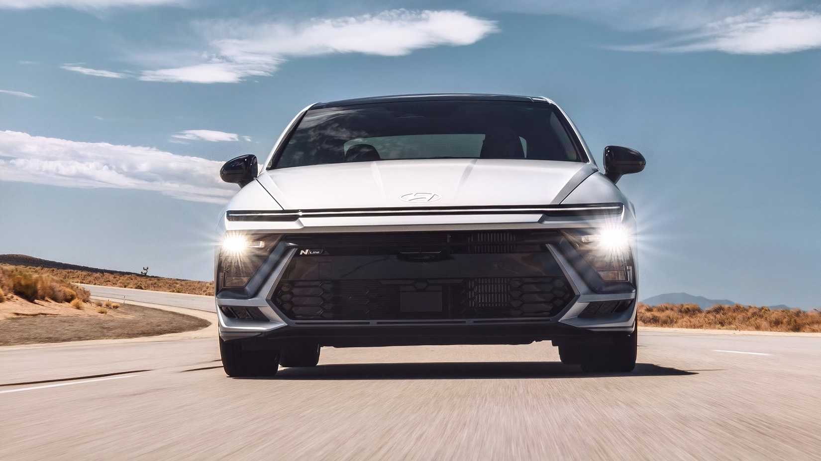 Frnt shot of a 2026 Hyundai Sonata Hybrid driving around corner