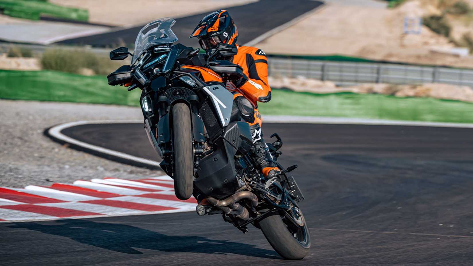 Front view action shot of the 2026 KTM 1390 Super Adventure S EVO doing a wheelie. 