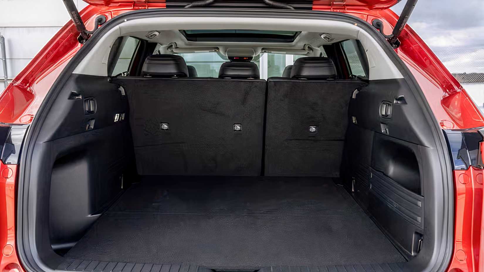 Foto do interior do porão de carga de um Mazda CX-50 2026 vermelho