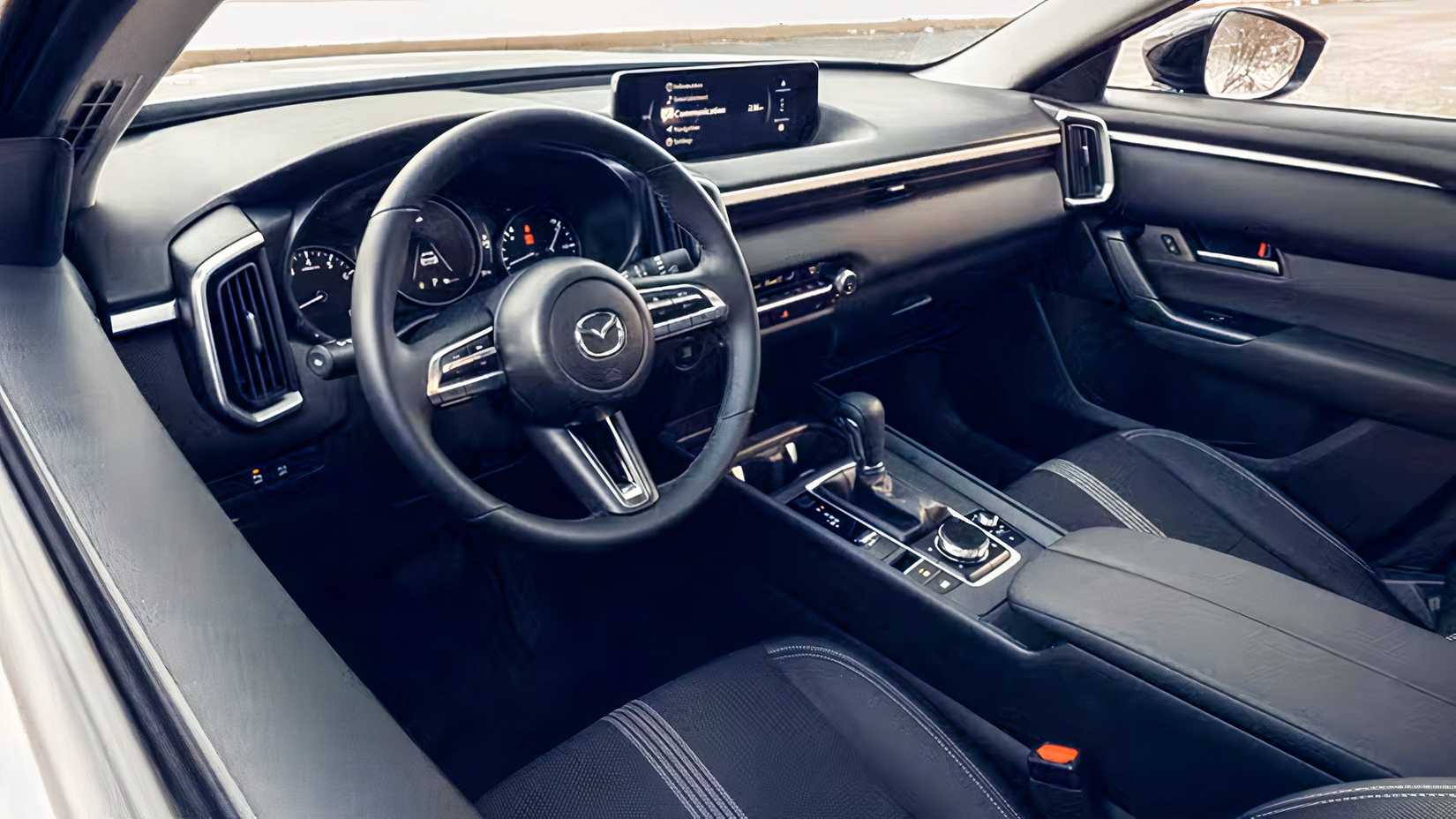 Foto do interior de um Mazda CX-50 2026 mostrando a cabine do lado do motorista