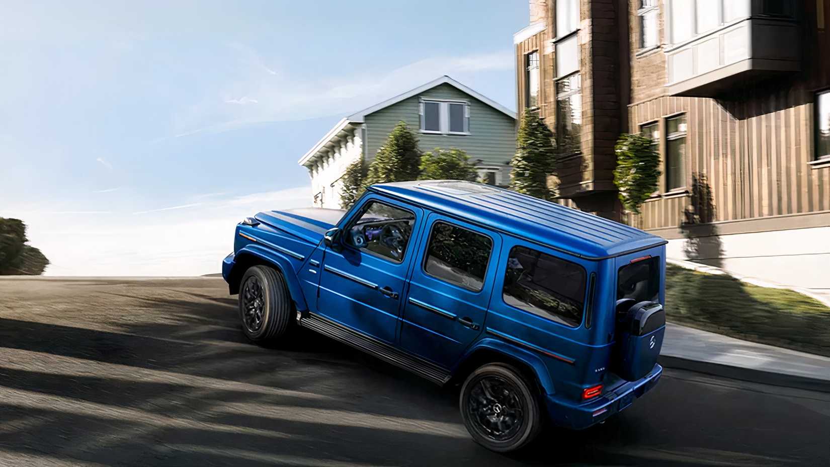 A side and rear 3/4 shot of a 2026 Mercedes-Benz G-Class SUV in driveway